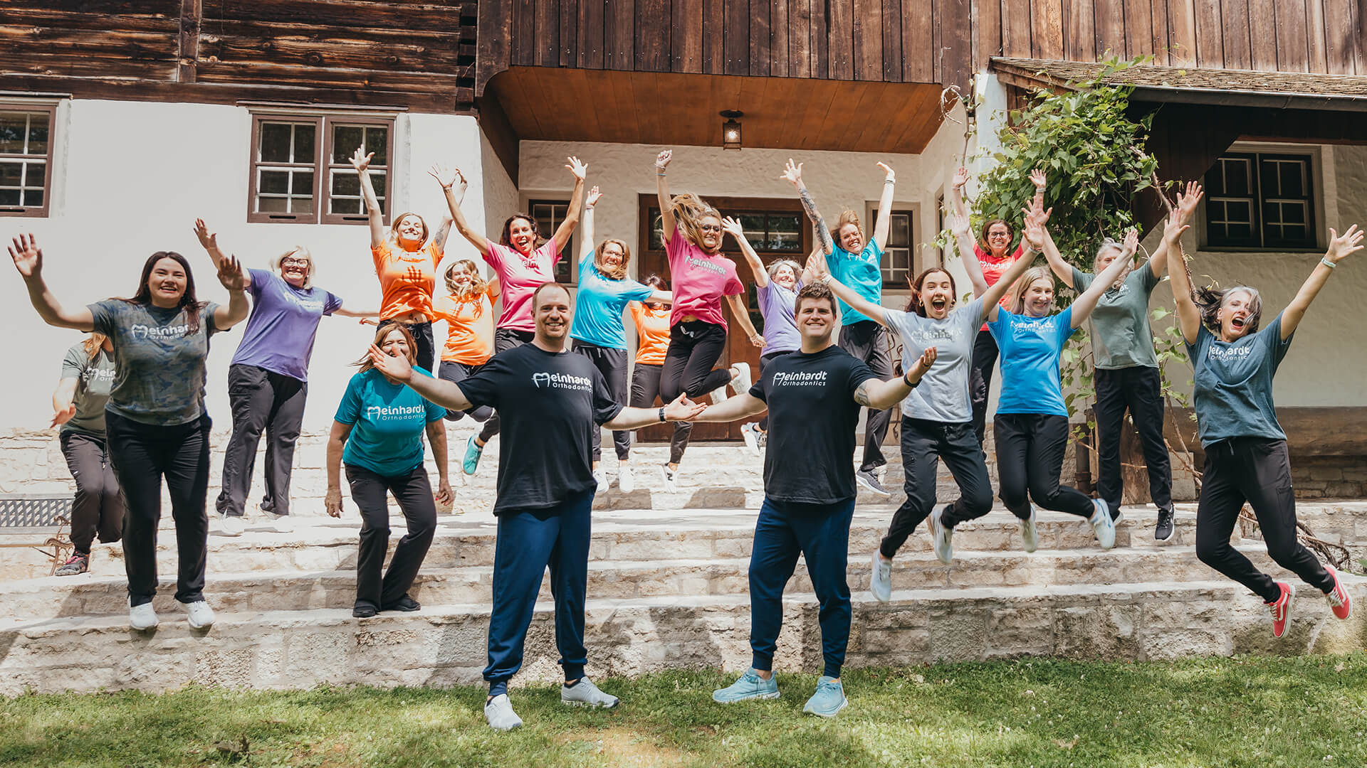 Meinhardt team jumping and smiling outside